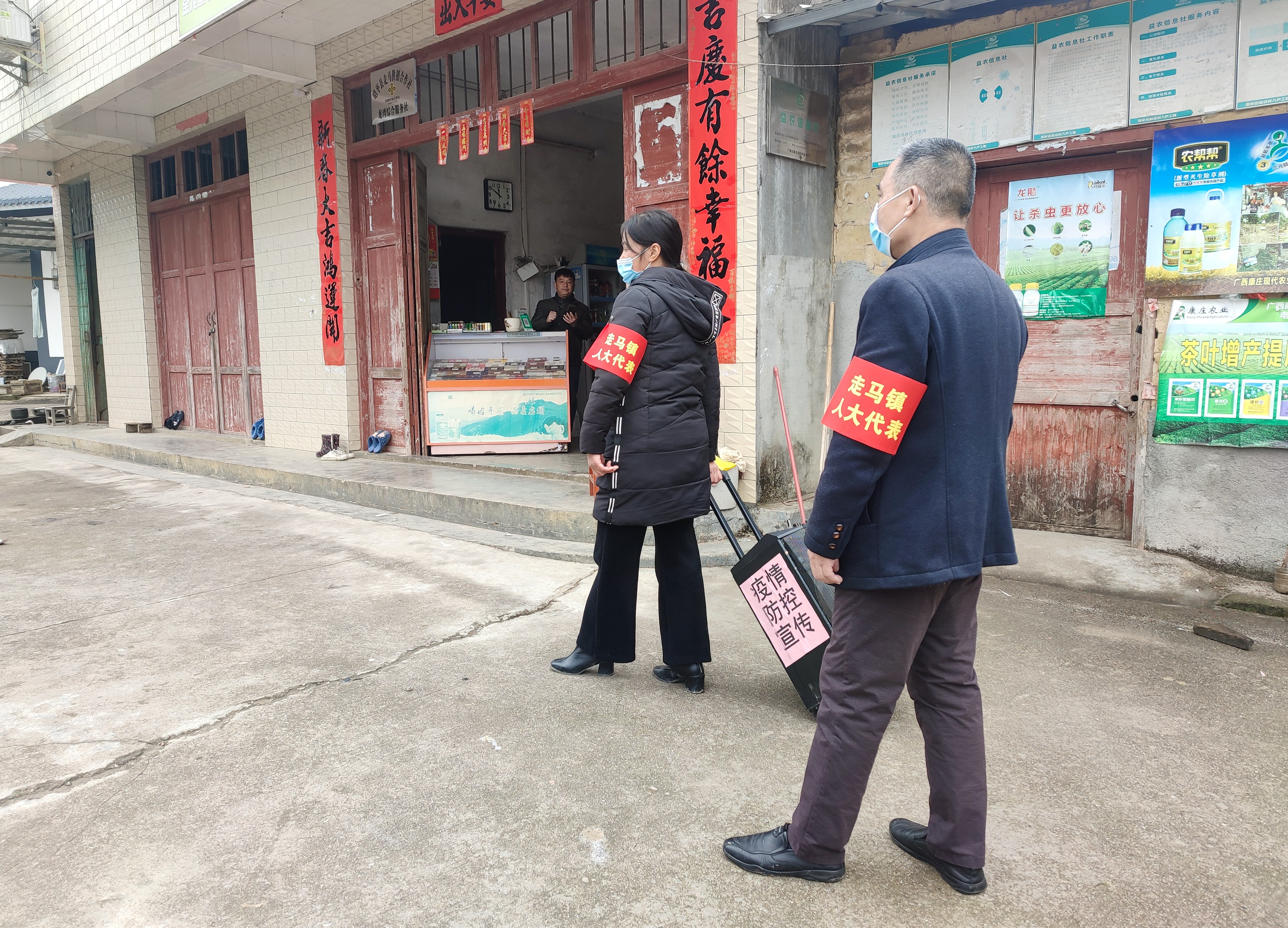 图为走马镇人大代表谢日清、莫林在村屯和重点场所宣传疫情防控工作.jpg